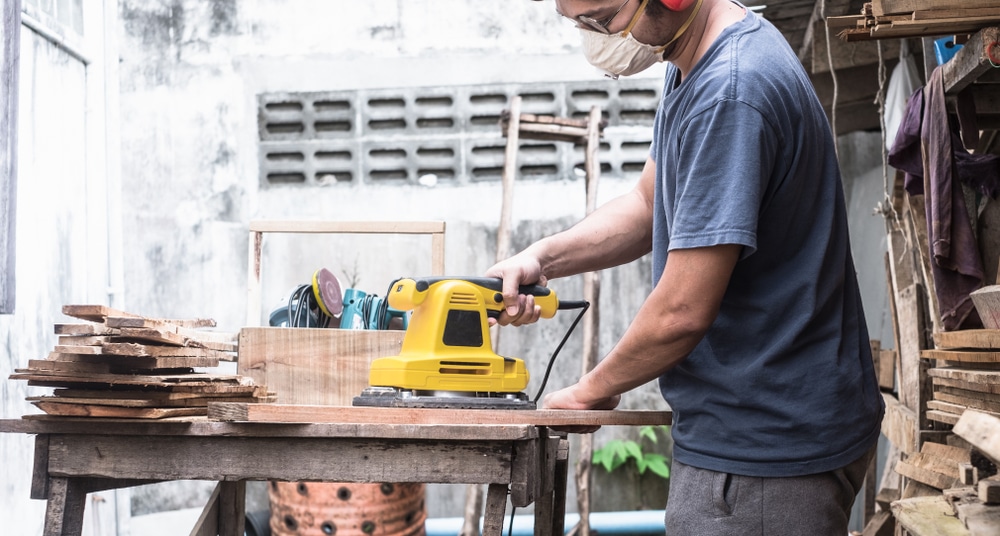 Carpenter Sanding Plank Wood Using Rectangular Orbit Sander Electric Power