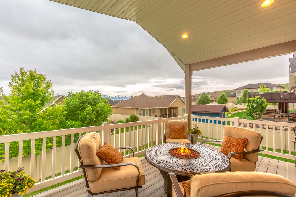 Chairs around table with fire pit at a residential balcony framed with railings