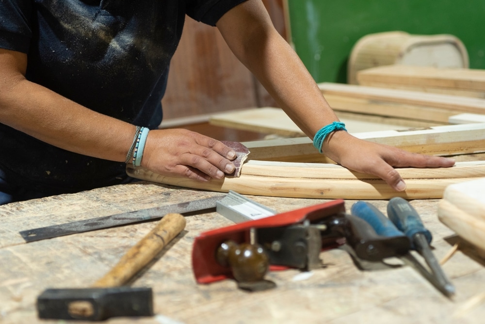 Hands Of A Female Carpenter Sanding Wood With Sandpaper To