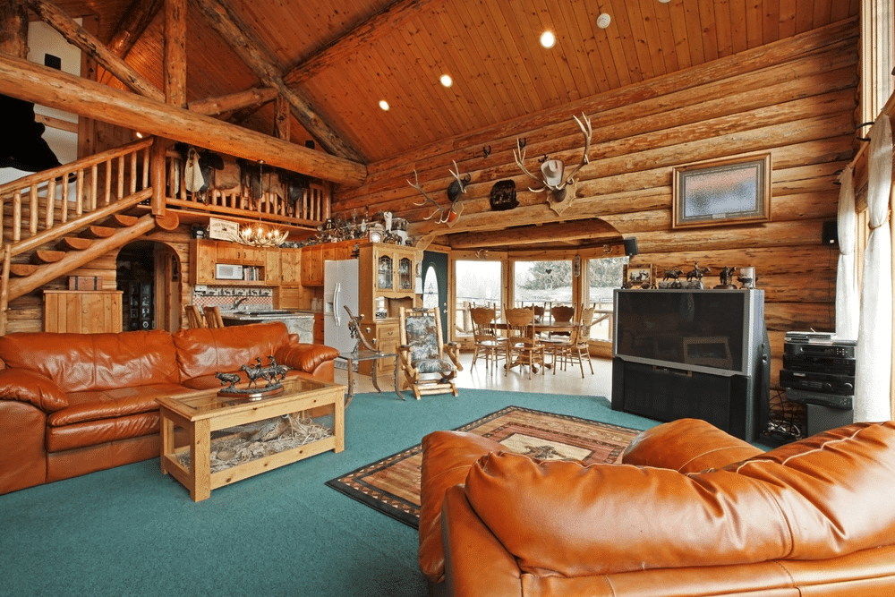 a large living room made of the log wood