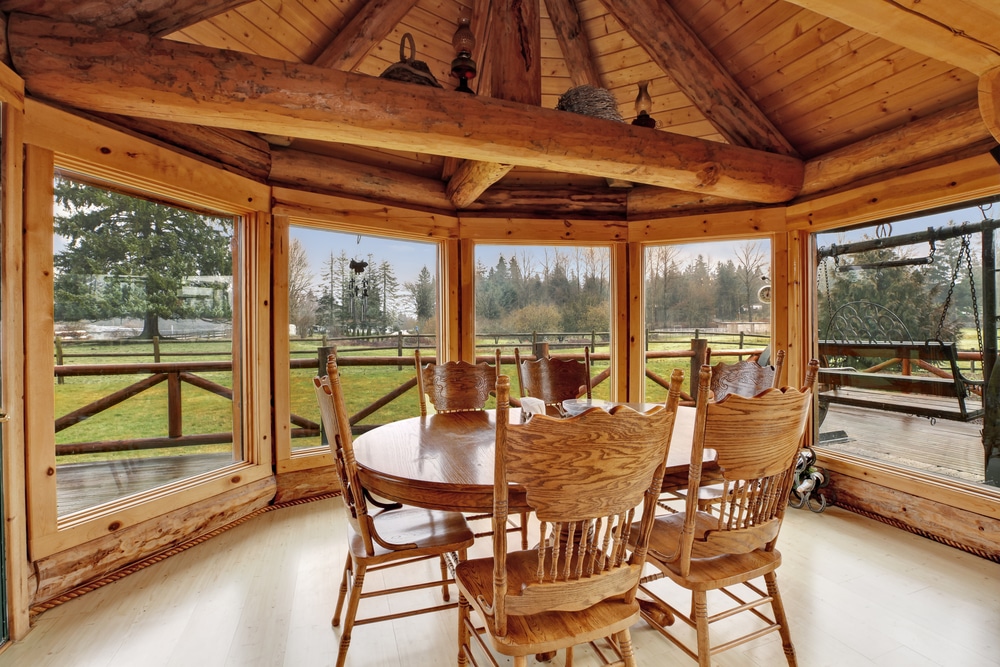 Bright Dining Room In Log Cabin House With Floor to ceiling Windows